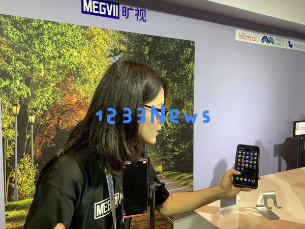 商汤的工作人员在演示AI加持的面部识别解锁